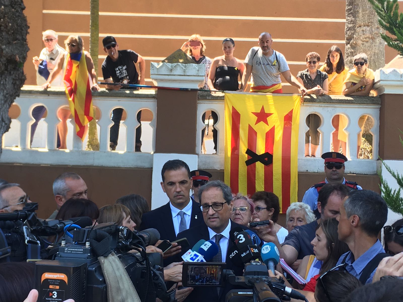 Quim Torra atenent la premsa, sota l'atenta mirada de Carles Motas, a l'exterior del Cementiri. Quim Torra SFG